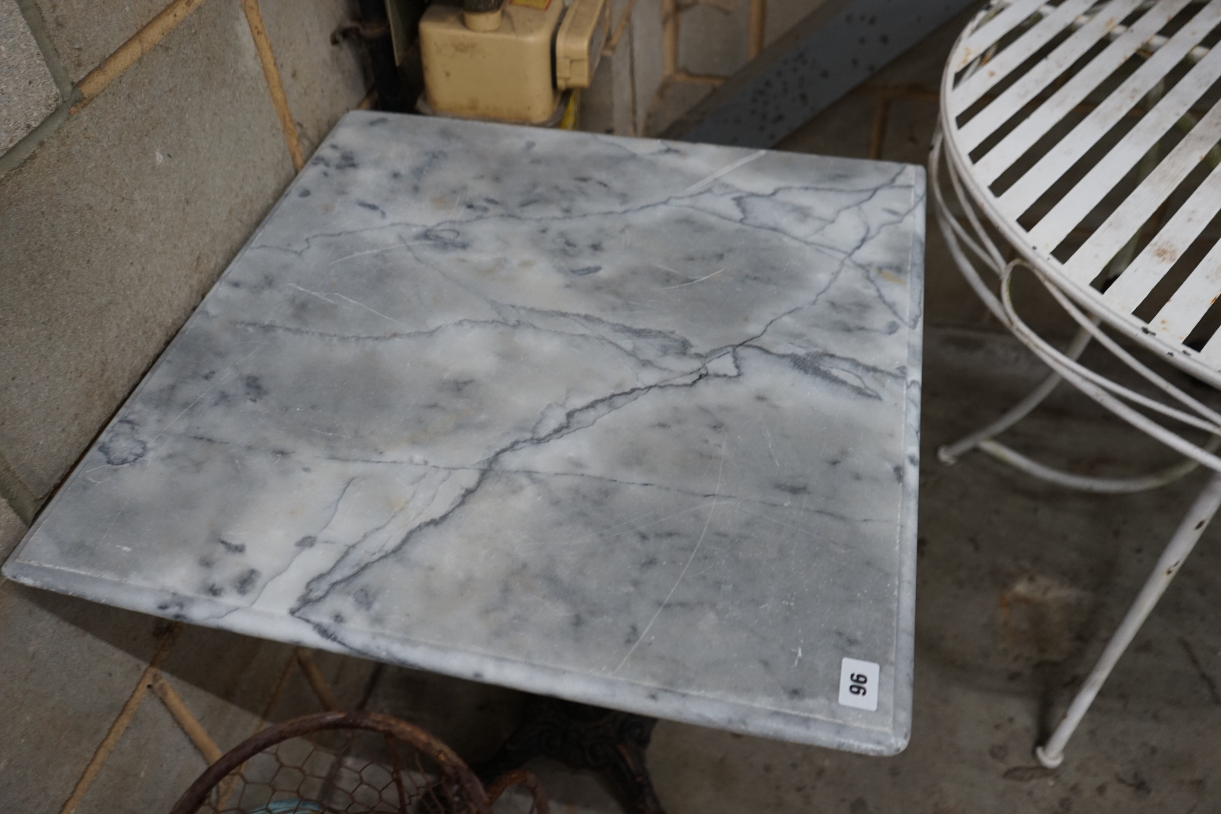 A reconstituted marble and cast iron garden table, width 60cm height 73cm